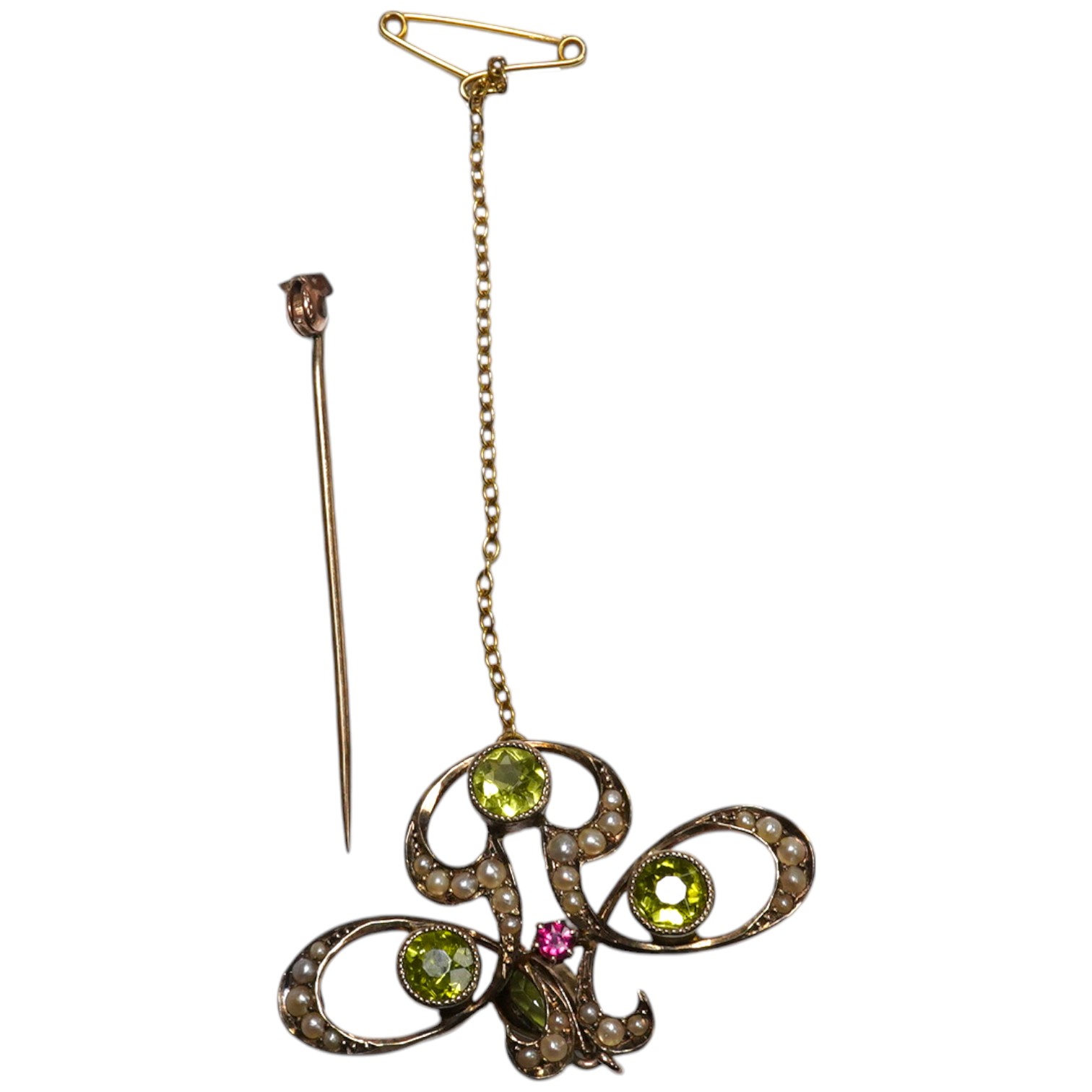 An early 20th century yellow metal, peridot, seed pearl and ruby cluster set drop pendant brooch (pin broken), width 35mm, gross weight 3.6 grams. Condition - poor